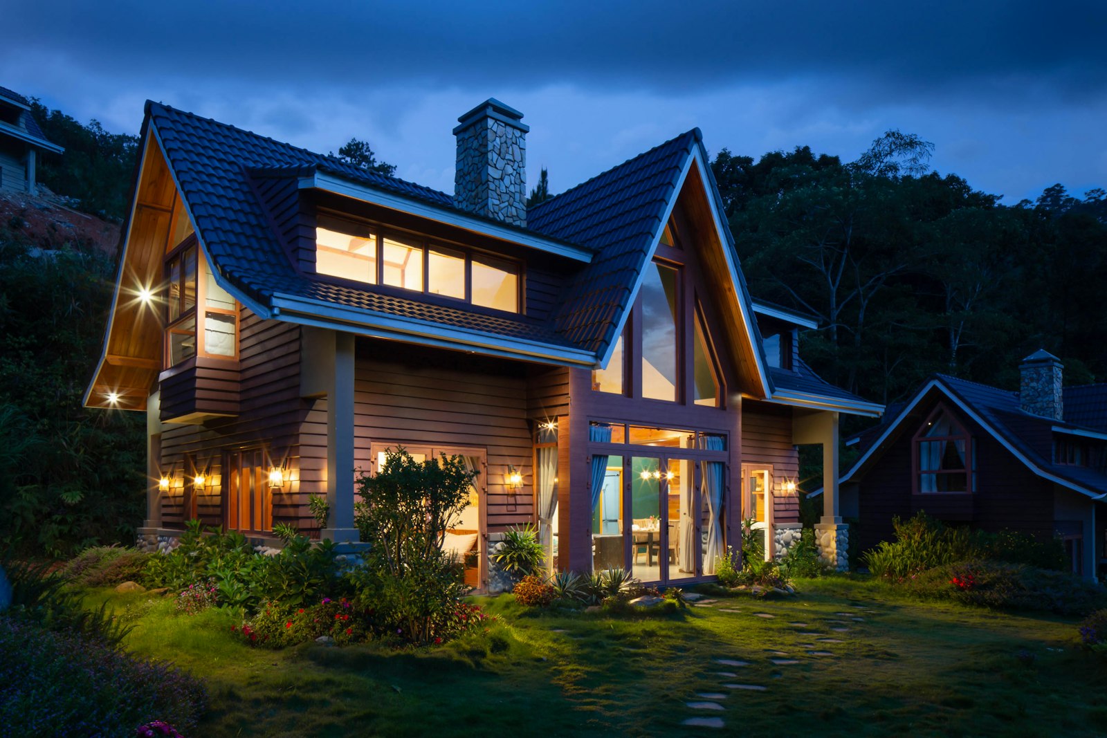 A lit A-frame home at dusk